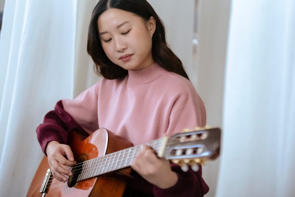 fingernails for fingerstyle guitar; Woman playing guitar